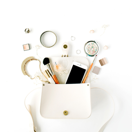 flat lay feminine arrangement with phone, accessories, purse, cosmetics on white, flat lay, top viewの写真素材