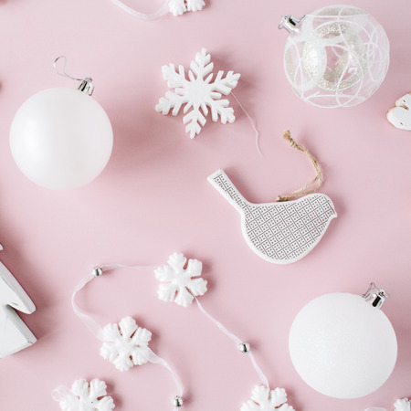 pattern made of white christmas decoration with christmas glass balls, tinsel, bow, elk, bird on pink background. christmas wallpaper. flat lay, top viewの写真素材