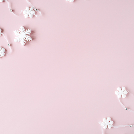 white christmas snowflakes decoration on pink background. christmas wallpaper. flat lay, top viewの写真素材