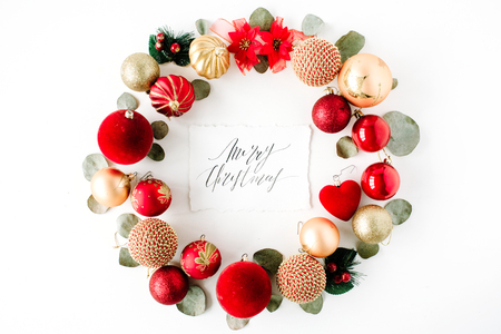 christmas wreath frame made of colored bright christmas balls and calligraphy words merry christmas on white background. flat lay, top viewの写真素材