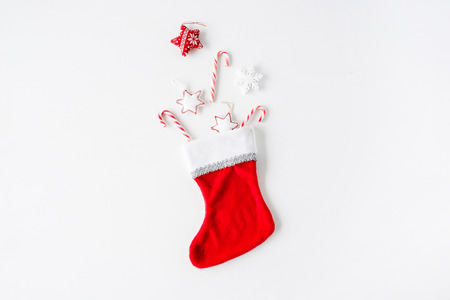 creative arrangement of bright red christmas toys in christmas sock on white background. flat lay, top viewの写真素材