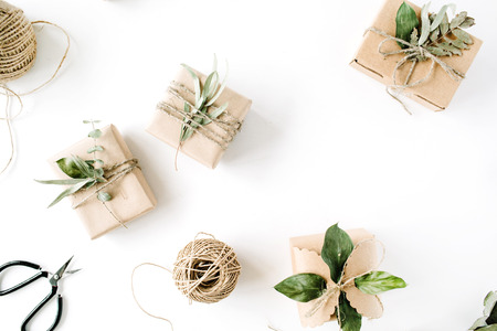 creative arrangement pattern of craft boxes and green branches on white background. flat lay, top viewの写真素材