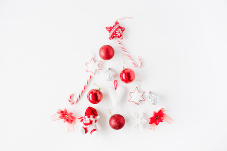 creative arrangement of bright red christmas tree made of christmas ball, sweets, toys on white background. flat lay, top viewの写真素材