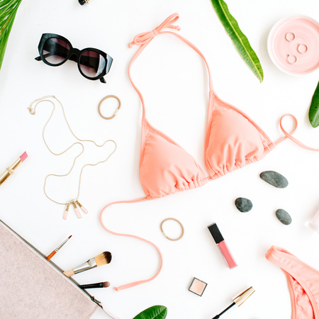 female summer bikini swimsuit and accessories collage on white with palm branches, necklace and sunglasses. flat lay, top viewの写真素材