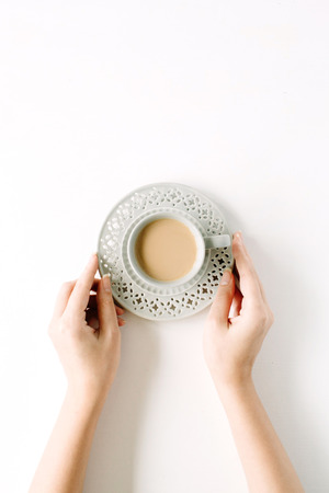 girl's hands holding coffee cup. flat lay, top viewの写真素材