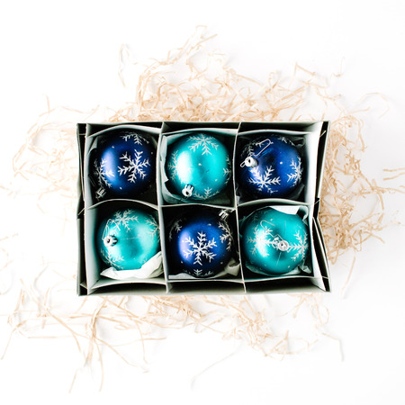 box with bright blue christmas balls on white background. flat lay, top viewの写真素材