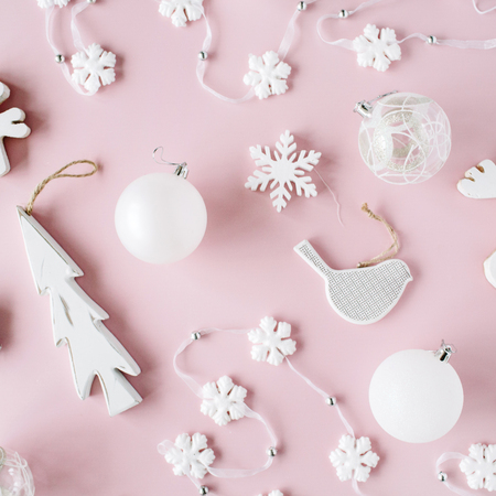 pattern made of white christmas decoration with christmas glass balls, tinsel, bow, elk, bird on pink background. christmas wallpaper. flat lay, top viewの写真素材