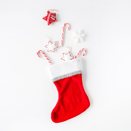 creative arrangement of bright red christmas toys in christmas sock on white background. flat lay, top viewの写真素材