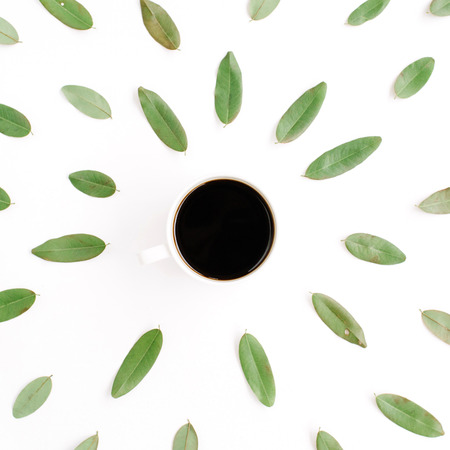 black coffee cup and floral pattern with green petals. flat lay, top viewの写真素材