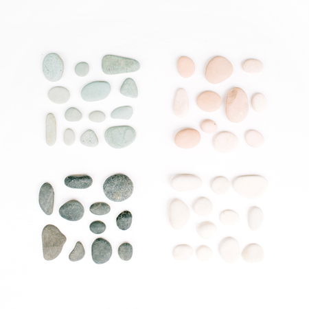 Creative arrangement of colored stones. Mint, pink, beige and grey stones on white. Flat lay, top viewの写真素材