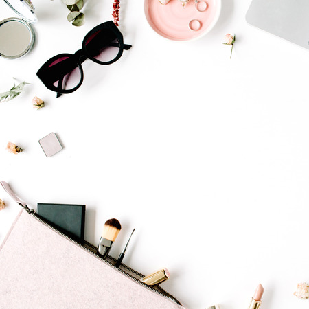 Flat lay, top view office table desk frame. feminine desk workspace with laptop, clutch, cosmetics, phone, sunglasses, lipstick rose buds on white background.の写真素材