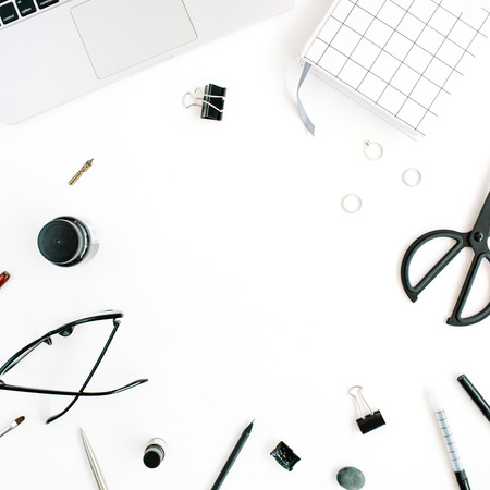 Flat lay, top view office table desk. Workspace with notebook, laptop, scissors, glasses, pen on white background.の写真素材