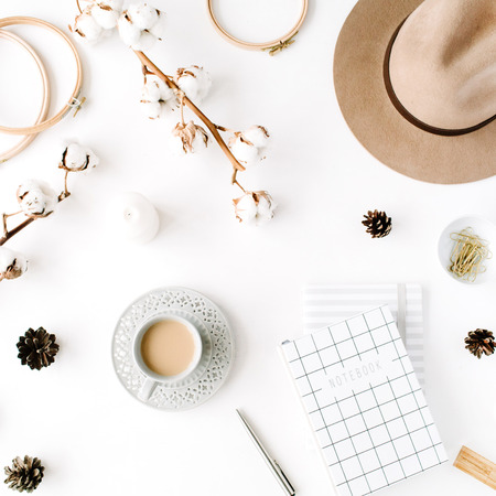 Flat lay trendy creative feminine accessories arrangement with coffee, cotton branch and diary. Hat, cotton branch, notebook, coffee cup, fir cone, golden clips on white background. Top viewの写真素材