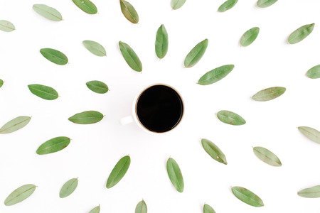 black coffee cup and floral pattern with green petals. flat lay, top viewの写真素材