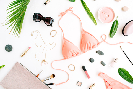 female summer bikini swimsuit and accessories collage on white with palm branches, necklace and sunglasses. flat lay, top viewの写真素材