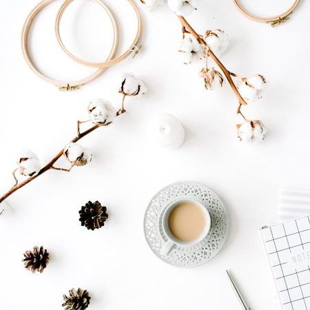 Flat lay trendy creative feminine accessories arrangement with coffee, cotton branch and diary. Hat, cotton branch, notebook, coffee cup, fir cone, golden clips on white background. Top viewの写真素材