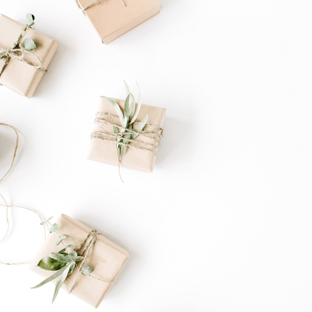 creative arrangement pattern of craft boxes and green branches on white background. flat lay, top viewの写真素材