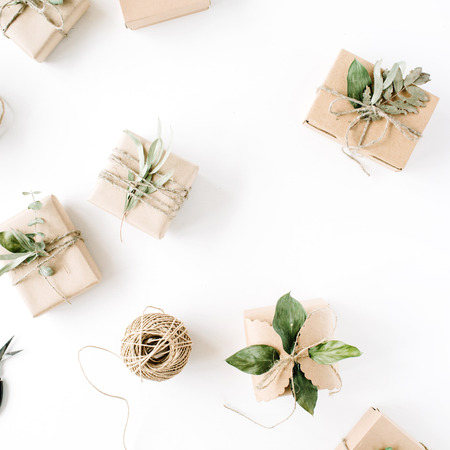 creative arrangement pattern of craft boxes and green branches on white background. flat lay, top viewの写真素材