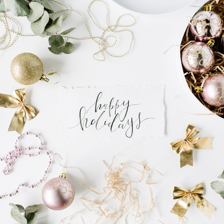 calligraphy words happy holidays and frame made of christmas decoration with christmas balls, tinsel, bow, eucalyptus. christmas wallpaper. flat lay, top viewの写真素材
