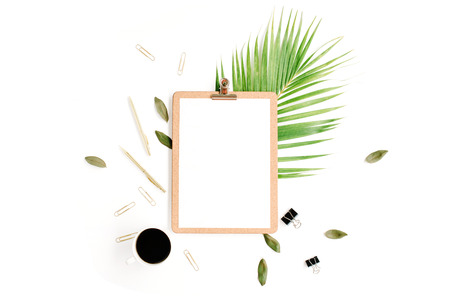 clipboard with empty copy space blank, coffee mug, golden pen and clips, petals and palm branch on white background. flat lay, top viewの写真素材