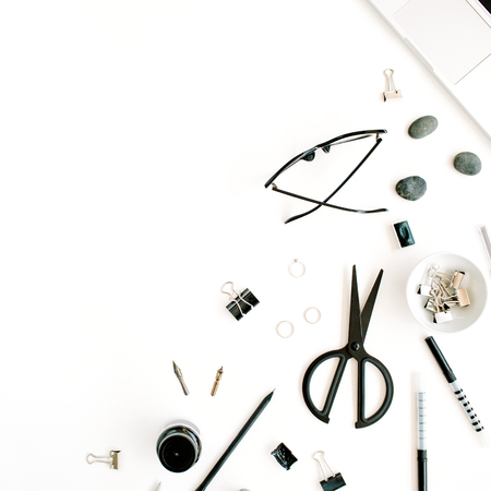 Flat lay, top view office table desk. Workspace with laptop, scissors, glasses, pen on white background.の写真素材