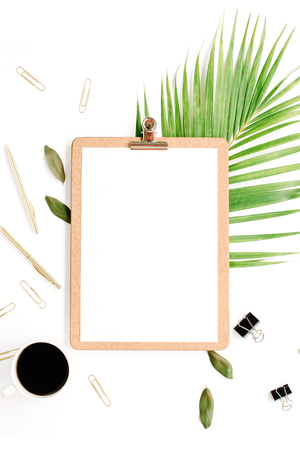 clipboard with empty copy space blank, coffee mug, golden pen and clips, petals and palm branch on white background. flat lay, top viewの写真素材