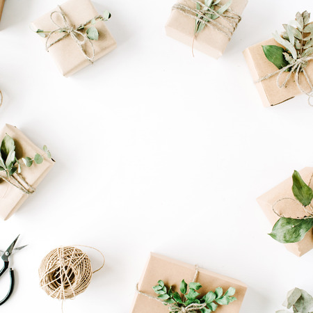 creative arrangement frame of craft boxes and green branches on white background. flat lay, top viewの写真素材