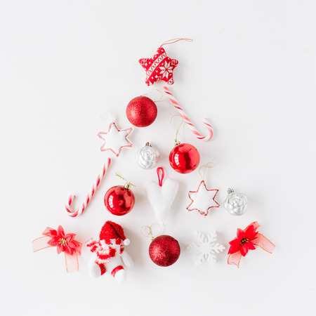 creative arrangement of bright red christmas tree made of christmas ball, sweets, toys on white background. flat lay, top viewの写真素材