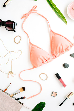 female summer bikini swimsuit and accessories collage on white with palm branches, necklace and sunglasses. flat lay, top viewの写真素材