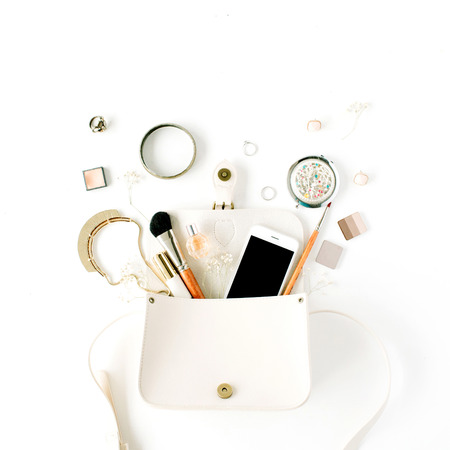 flat lay feminine arrangement with phone, accessories, purse, cosmetics on white, flat lay, top viewの写真素材