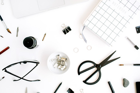 Flat lay, top view office table desk. Workspace with notebook, laptop, scissors, glasses, pen on white background.の写真素材