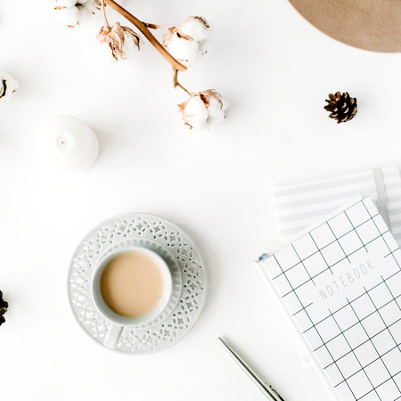 Flat lay trendy creative feminine accessories arrangement with coffee, cotton branch and diary. Hat, cotton branch, notebook, coffee cup, fir cone on white background. Top viewの写真素材