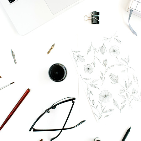 Flat lay, top view office table desk. Workspace with painting, notebook, laptop, scissors, glasses, pen on white background.の写真素材