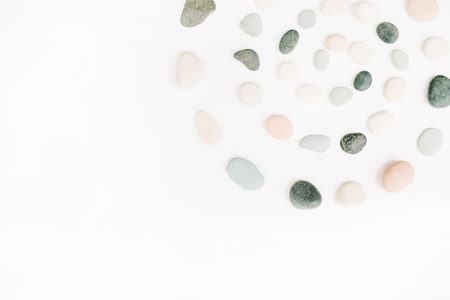 Creative spiral arrangement of colored stones. Mint, pink, beige and grey stones on white. Flat lay, top viewの写真素材