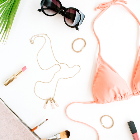 female summer bikini swimsuit and accessories collage on white with palm branches, necklace and sunglasses. flat lay, top viewの写真素材