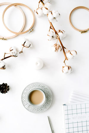 Flat lay trendy creative feminine accessories arrangement with coffee, cotton branch and diary. Cotton branch, notebook, coffee cup, fir cone on white background. Top viewの写真素材