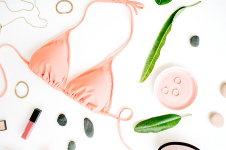female summer bikini swimsuit and accessories collage on white with palm branches, necklace and lipstick. flat lay, top viewの写真素材