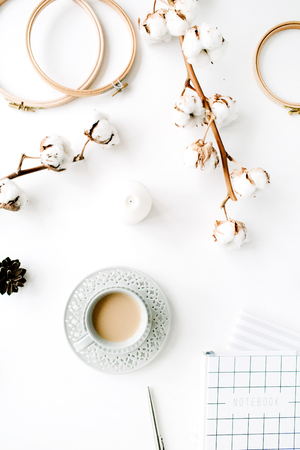 Flat lay trendy creative feminine accessories arrangement with coffee, cotton branch and diary. Cotton branch, notebook, coffee cup, fir cone on white background. Top viewの写真素材