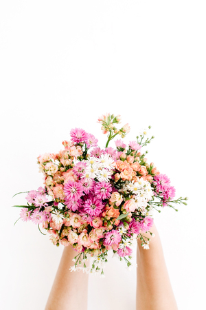 Girl's hands holding wildflowers bouquet on white background. Flat lay, top viewの写真素材
