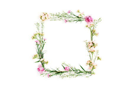 Wreath frame made of pink and beige wildflowers, green leaves, branches on white background. Flat...