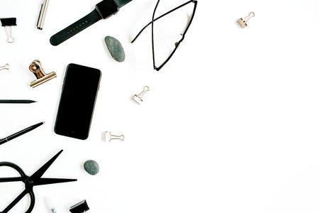 White office table desk with supplies. mobile phone, glasses, scissors and office supplies on white...