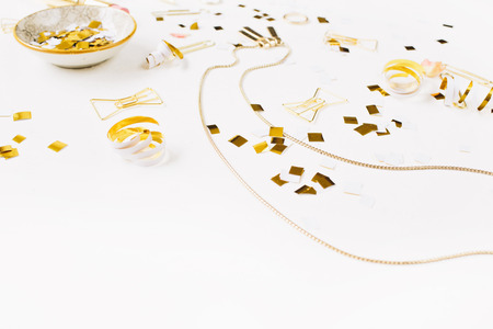 Beauty blog background. Gold style feminine accessories. Golden tinsel, pen, rings on white background. Top view.の写真素材