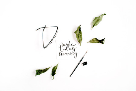 Inspirational quote "Make Today Amazing" written in calligraphic style on paper with green leaf and glasses on white background. Flat lay, top viewの写真素材