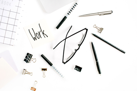 White office desk frame with word Work and supplies. Laptop, notebook, pen, clips, glasses and office supplies on white background. Flat lay, top view, mockup.の写真素材