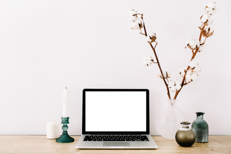 Blogger or freelancer workspace with front view of laptop with blank screen at white background. Minimalistic decorated home office desk.の写真素材
