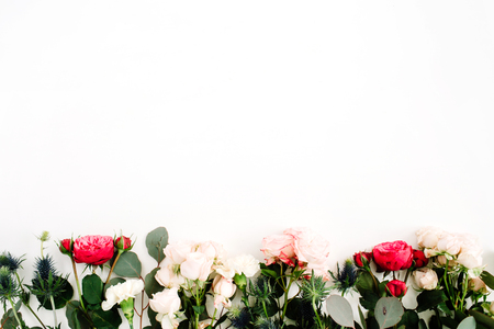 Red and beige rose flowers, eringium flower, eucalyptus branches and leaves on white background. Flat lay, top view. Floral backgroundの写真素材