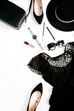 Trendy fashion black styled woman clothes and accessories collection on white background. Flat lay, top view. Dress, high heels, sunglasses, purse, watches.の写真素材