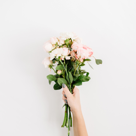 Beautiful pink rose flower bouquet in girls hand isolated on white background. Flat lay, top view. Floral compositionの写真素材