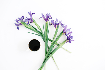 Cup of coffee and purple iris flowers on white background. Flat lay, top view.の写真素材