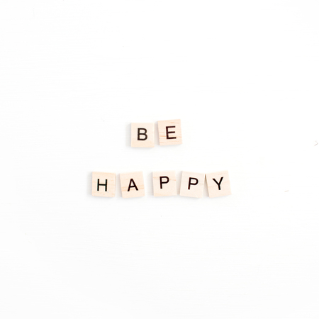 Quote Be Happy with wooden tiles on white background. Flat lay, top viewの写真素材
